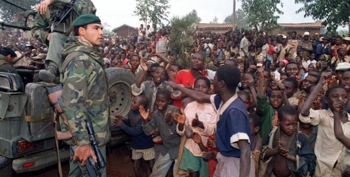 Hutu refugees greet French marines arriving in a camp four kilometers outside Butare 03 July 1994 as Rwandan rebels clashed with French forces on the outskirts of the city for the first time in the 10-days-old Operation Turquoise.