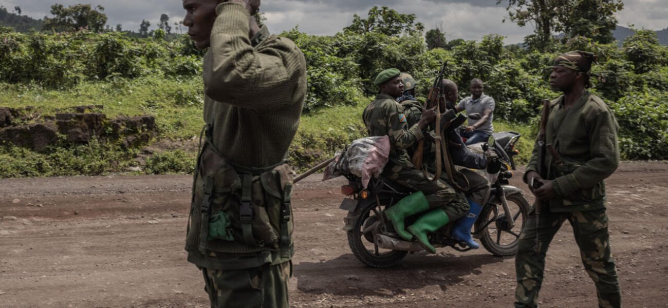 A motorcyclist carries soldiers as others patrol the area in Kibumba that was attacked by M23 rebels in clashes with the Congolese army, near the town of Goma in eastern Democratic Republic of Congo, June 1, 2022. (Photo by Guerchom Ndebo / AFP)
