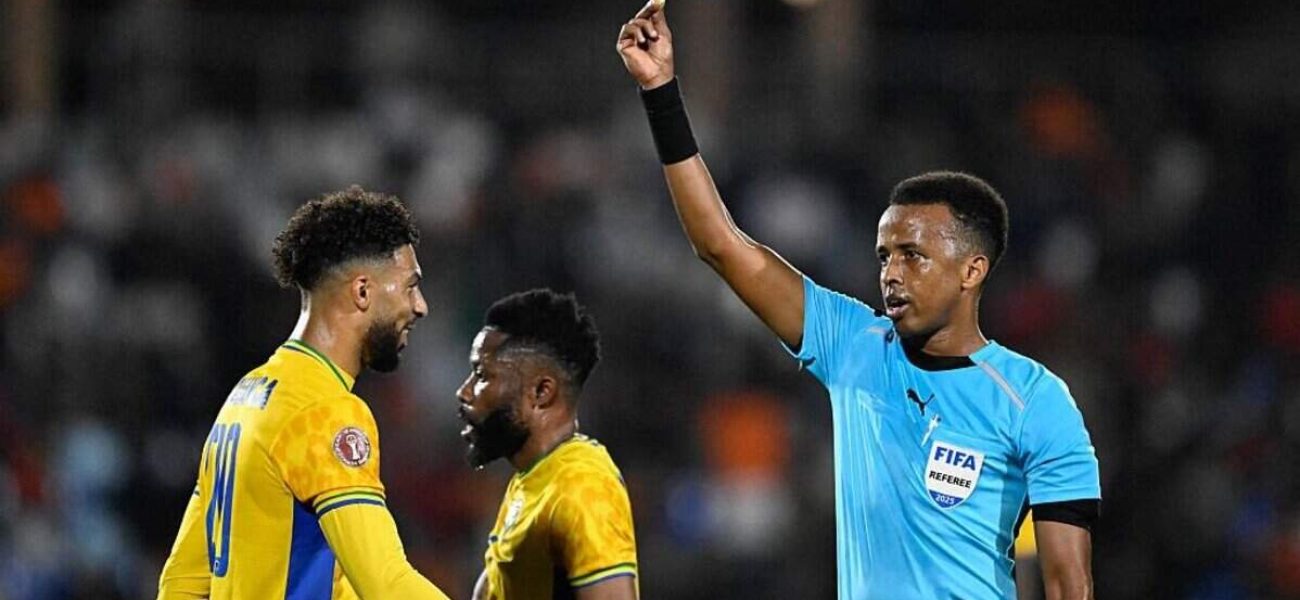 Gabon's forward #20 Denis Bouanga is shown the yellow card by Somali referee Omar Abdulkadir Artan during the Africa Cup of Nations (CAN) Group F football match between Gabon and Ivory Coast at the Grand Stadium in Marrakech on December 31, 2025. (Photo by Khaled DESOUKI / AFP via Getty Images)