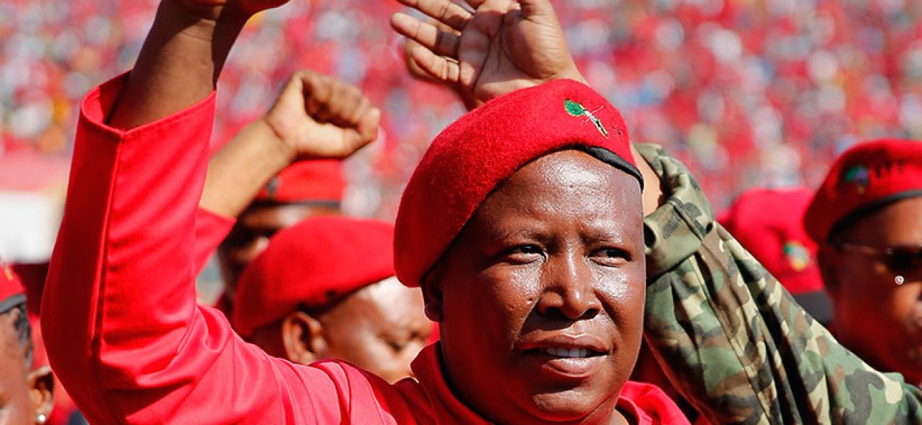 PRETORIA, SOUTH AFRICA - MAY 04:  Commander and chief of the Economic Freedom Fighters and South African presidential candidate Julius Malema greets supporters as he enters the Lucas Moripe Stadium for an Economic Freedom Fighters presidential campaign rally at the Lucas Moripe Stadium on May 4, 2014 in Pretoria, South Africa. The rally comes prior to the South African presidential elections which are scheduled to be held on May 7, 2014. (J. Countess/Getty Images)