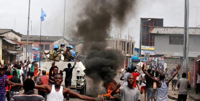 Residents chant slogans against Congolese President Joseph Kabila as peacekeepers MONUSCO patrol during demonstrations in the streets of the DRC capital Kinshasa