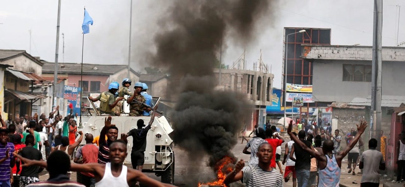 Residents chant slogans against Congolese President Joseph Kabila as peacekeepers MONUSCO patrol during demonstrations in the streets of the DRC capital Kinshasa