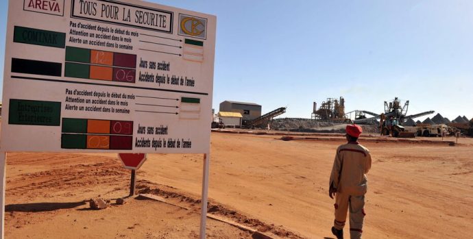 A man walks outside the entrance to France's state-owned nuclear giant Areva's uranium mine on September 26, 2010 in Arlit.    Gunmen seized the five French nationals, most working for France's state-owned nuclear giant Areva or its engineering sub-contractor Satom, amd a Togolese and a Madagascan in a raid on September 16 on a uranium mining town in the deserts of northern Niger. Army chiefs and counter-terrorism experts from the Sahel region were meeting Sunday in southern Algeria in a bid to come to grips with the growing threat of Al-Qaeda-linked militants. AFP PHOTO / ISSOUF SANOGO (Photo by ISSOUF SANOGO / AFP)
