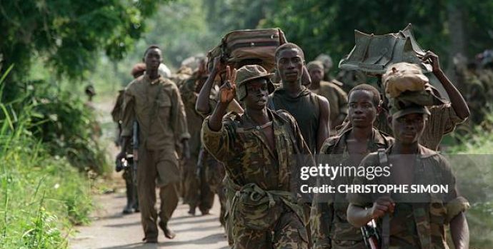 A soldier from Laurent Desire Kabila's the Alliance of Democratic Forces for the Liberation of Congo-Zaire flashes a Victory sign as he proceeds along with his comrades to Kinshasa 18 May 1997. In October 1996, Zairean opposition leader Laurent Desire Kabila, as head of the newly formed Alliance of Democratic Forces for the Liberation of Congo-Zaire, rallied forces consisting mostly of Tutsi from eastern Zaire and launched a full-scale rebellion against Mobutu, forcing him to flee the country, following failed peace talks in May 1997. On 17 May 1997, Kabila installed himself as head of state and renamed the country the Democratic Republic of Congo. (Photo credit should read CHRISTOPHE SIMON/AFP via Getty Images)