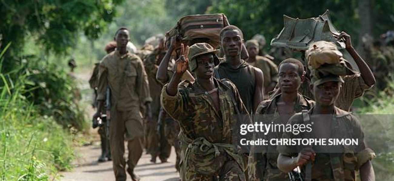 A soldier from Laurent Desire Kabila's the Alliance of Democratic Forces for the Liberation of Congo-Zaire flashes a Victory sign as he proceeds along with his comrades to Kinshasa 18 May 1997. In October 1996, Zairean opposition leader Laurent Desire Kabila, as head of the newly formed Alliance of Democratic Forces for the Liberation of Congo-Zaire, rallied forces consisting mostly of Tutsi from eastern Zaire and launched a full-scale rebellion against Mobutu, forcing him to flee the country, following failed peace talks in May 1997. On 17 May 1997, Kabila installed himself as head of state and renamed the country the Democratic Republic of Congo. (Photo credit should read CHRISTOPHE SIMON/AFP via Getty Images)