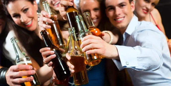 young-people-in-club-or-bar-drinking-beer-out-of-a-beer-bottle-and-have-fun