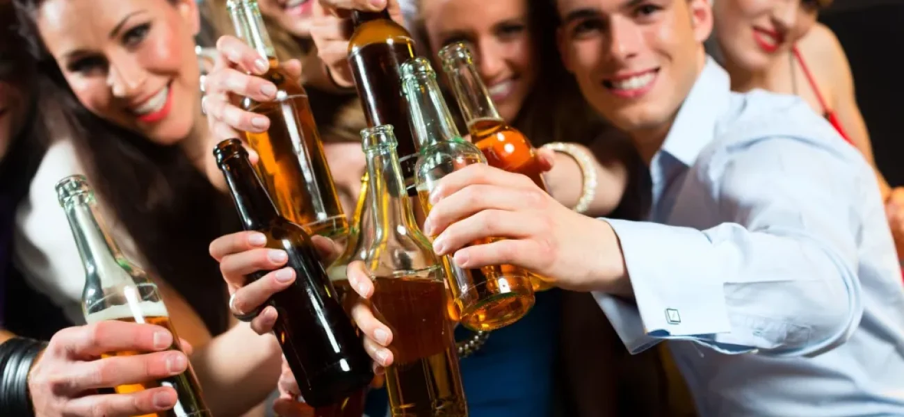 young-people-in-club-or-bar-drinking-beer-out-of-a-beer-bottle-and-have-fun